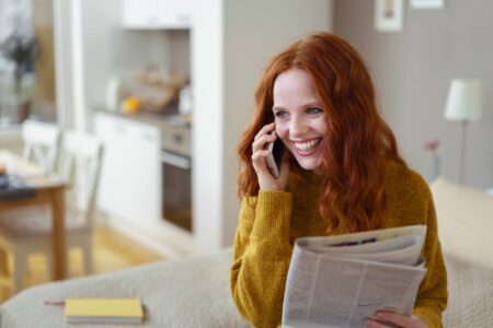 woman laughing on phone calling about shareholder perks