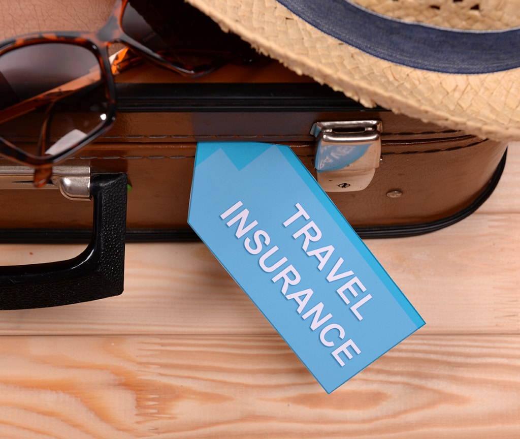 Suitcase and tourist stuff with inscription travel insurance on